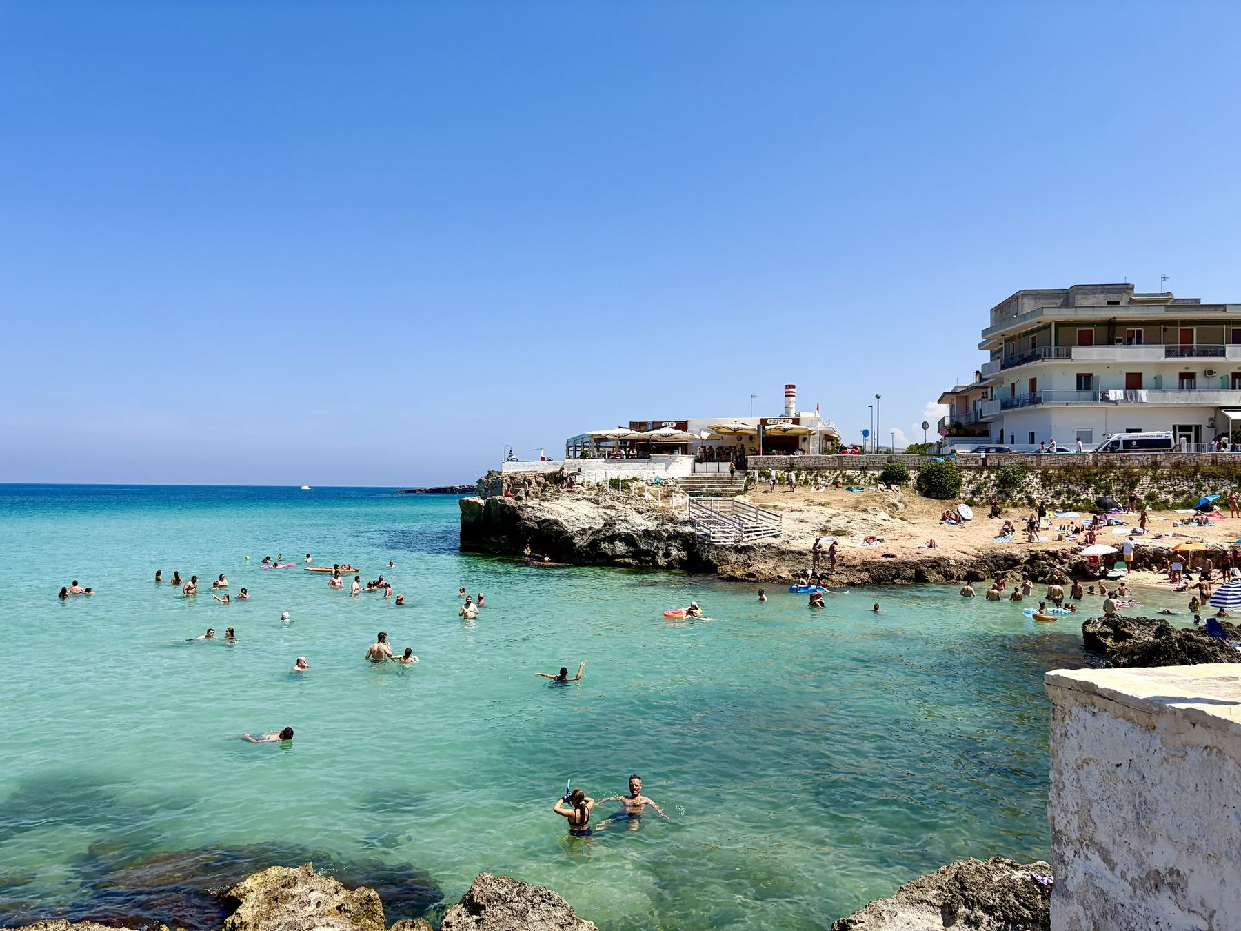 Monopoli cove, swimmers in the clear water